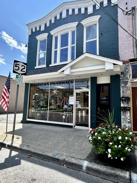The Matthews Pharmacy storefront on Canal Street in Ellenville, in afternoon sun